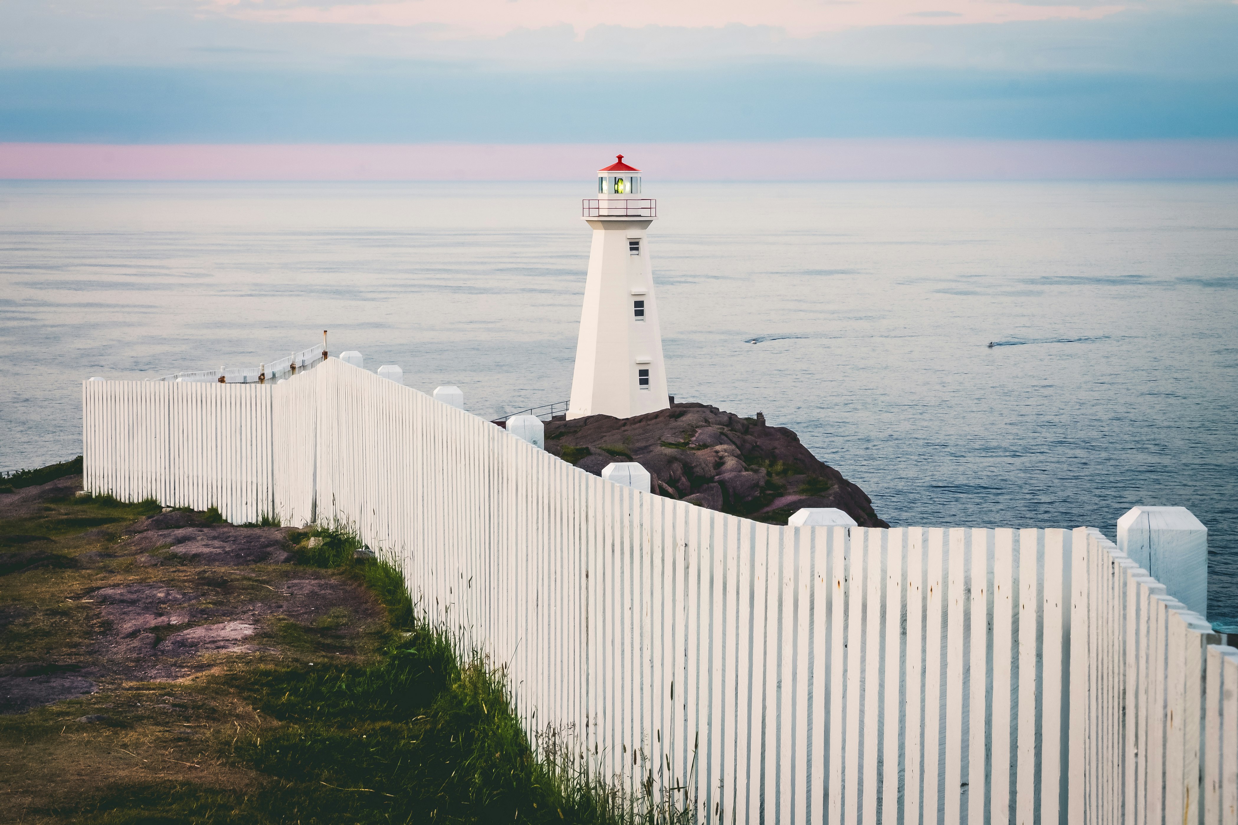 white lighthouse near body of water during daytime